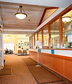 Interior of Jaffrey Family Medicine before renovations, showing the reception desk, glass partitions, and hallway.