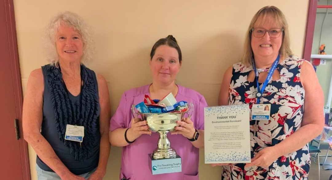 evs and hr employees pose with the traveling trophy