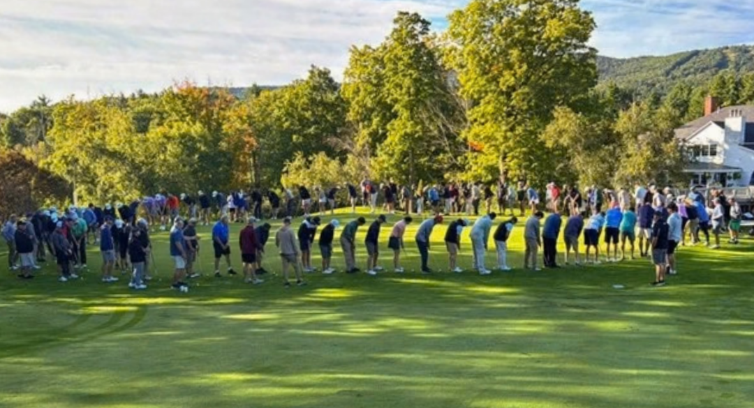 Golfers gather around the putting green for the Mega Putt event near the Crotched Mountain Golf Club clubhouse.