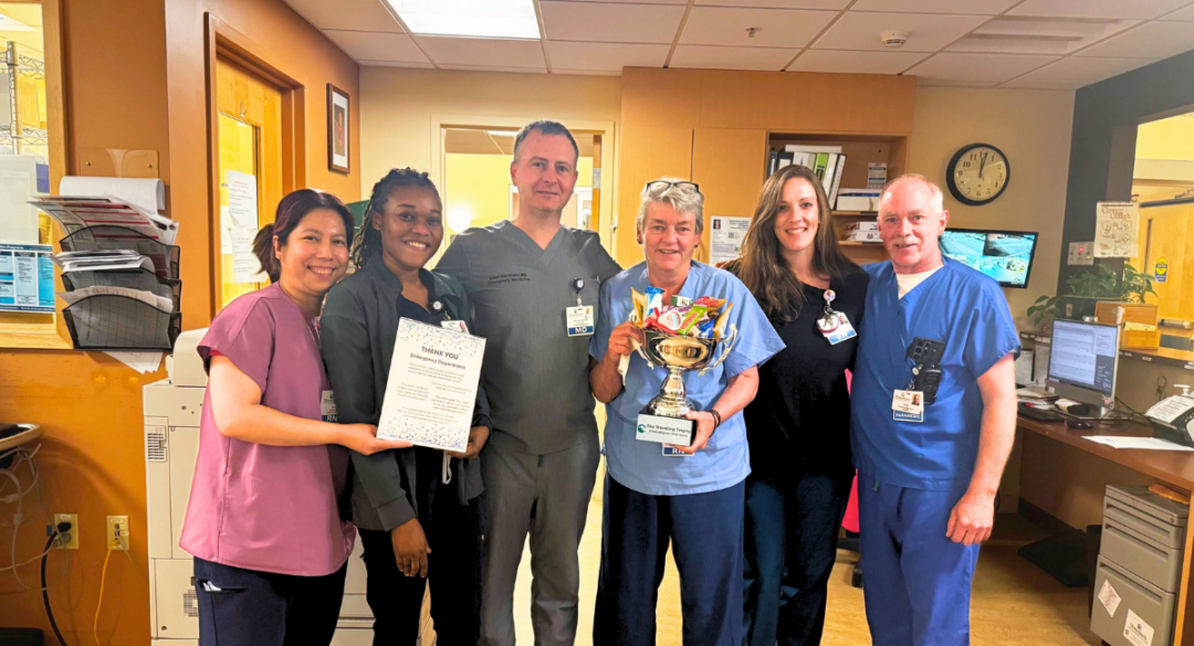 emergency department employees pose with the traveling trophy